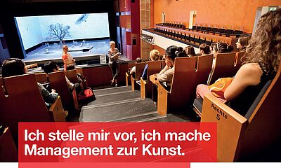 Das Theater als Hörsaal. Eine Bühne im Hintergrund, vor der zwei Frauen sprechen und junge Menschen hören zu.