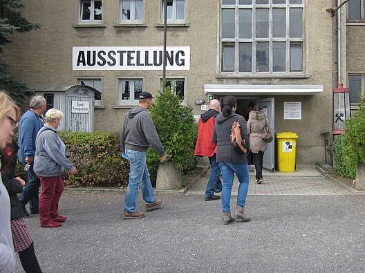 Eine Gruppe von Menschen steht vor dem Bauhaus Museum in Dessau.